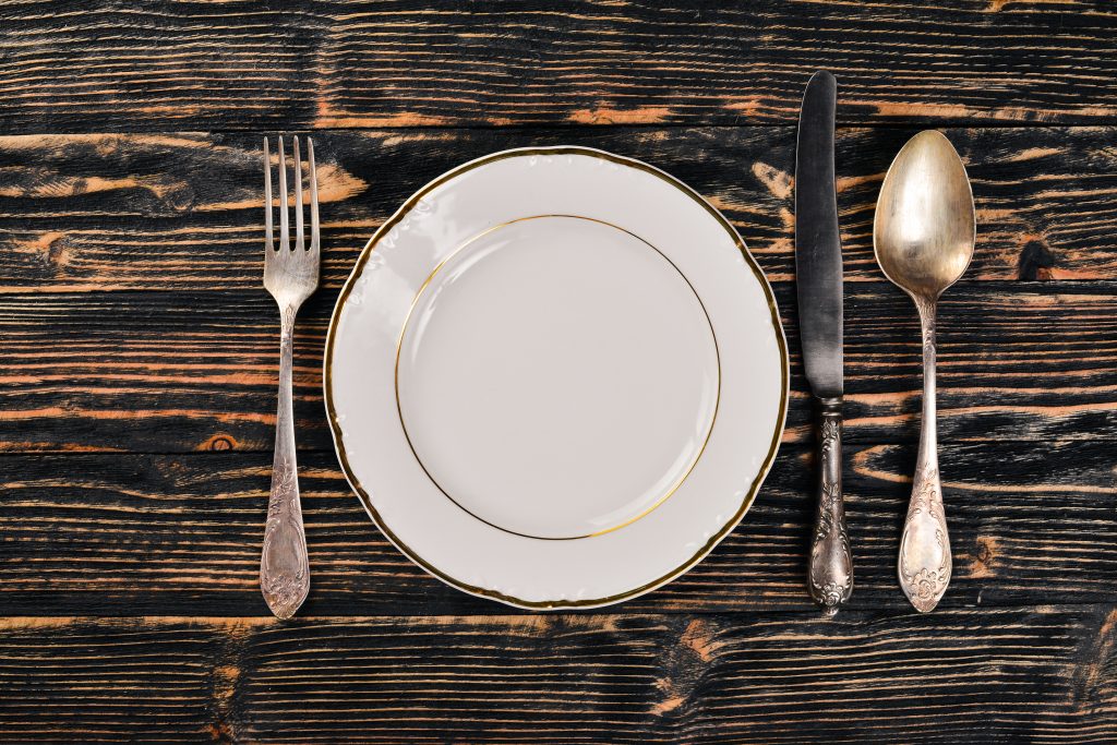 Plate and old cutlery. On a wooden background. Top view. Free space for text.